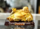 Phật di lạc vàng bóng tay cầm nén vàng nằm trên túi tài lộc vàng đế gỗ LN190